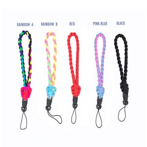 Peut inclure: Cinq lanières de téléphone tressées avec différentes combinaisons de couleurs : arc-en-ciel, rouge, rose et bleu, et noir. Chaque sangle est dotée d’un clip en plastique noir et d’une boucle à l’extrémité.