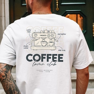Könnte beinhalten: Weißes T-Shirt mit einer Kaffeemaschinen-Skizze und dem Schriftzug "COFFEE lover club" auf dem Rücken. Das Diagramm enthält Beschriftungen wie "water tank" und "portafilter". Das Shirt trägt auch den Text "EVERY MORNING 7AM - 10AM".