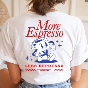 Könnte beinhalten: Weißes T-Shirt mit einer roten und blauen Grafik einer Cartoon-Kaffeetasse mit dem Text "More Espresso" und "Less Depresso" mit den Worten "Good Coffee for a Good Day" darunter.