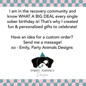 May include: A white card with text in black font, framed by a pink and teal checkered pattern. The text reads: "I am in the recovery community...fun & personalized gifts to celebrate!" and "Have an idea for a custom order? Send me a message!" A black dog wearing a party hat is at the bottom.
