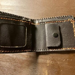 Cartera de piel cosida y pintada a mano.