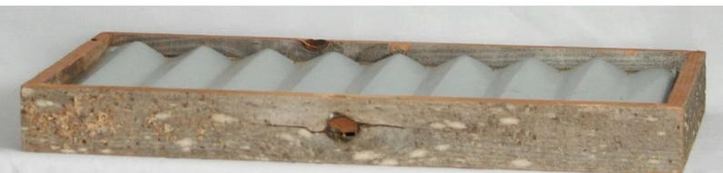 May include: A rectangular wooden tray with a light gray interior featuring a series of wave-shaped dividers. The tray has a rustic, weathered appearance with visible wood grain and knots. The frame is made of a darker wood.