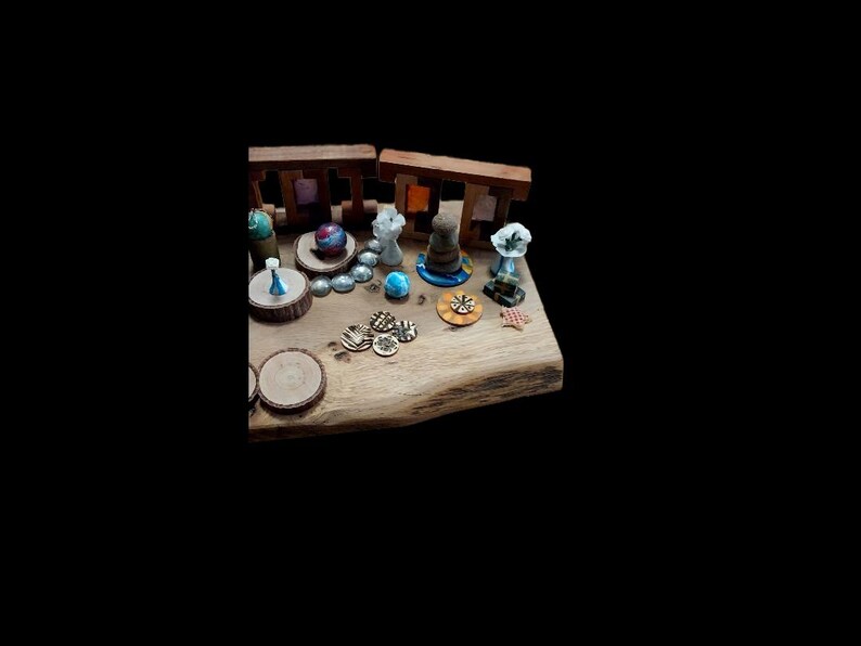 May include: A collection of miniature figurines and decorative elements arranged on a wooden surface. The display includes small sculptures, wooden cutouts, and colorful accents, creating a whimsical and artistic arrangement.
