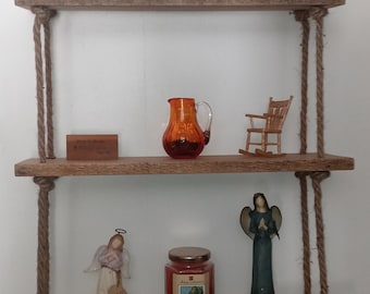 May include: Three wooden shelves with rope hangers, decorated with figurines, a pitcher, a candle, and a sign that reads "From the Ranch to You".