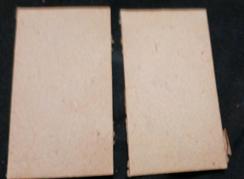 May include: Two blank, light brown, rectangular cards.