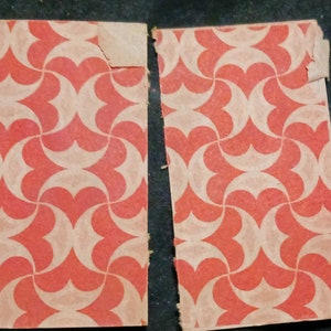 May include: Two pieces of red and white patterned wrapping paper. The paper has a geometric design of overlapping circles and hearts.