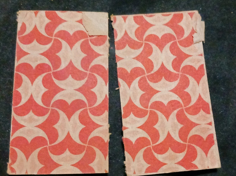 May include: Two pieces of red and white patterned wrapping paper. The paper has a geometric design of overlapping circles and hearts.