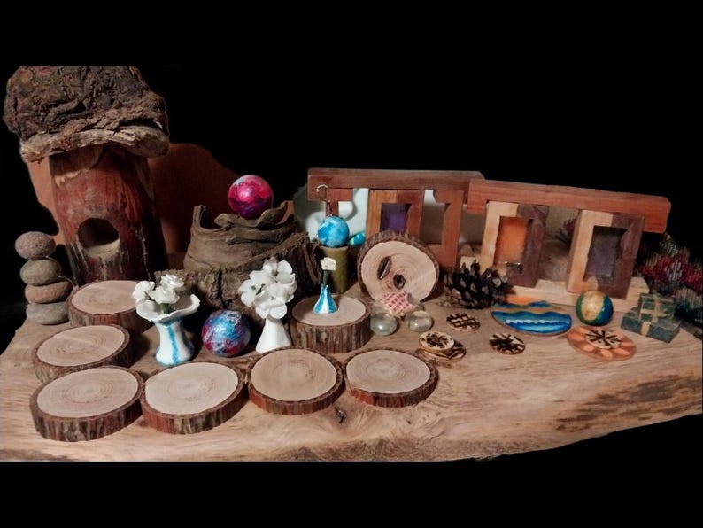 May include: A collection of decorative items, including wooden coasters, small vases, and miniature wooden frames, arranged on a large wooden slab. The items feature various colors and textures, creating a rustic and artistic display.