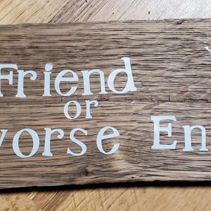May include: A rectangular wooden sign with the words "Best Friend or Worse Enemy" in white lettering. Above the word "Enemy" is the phrase "you decide". The wood has a natural, rustic appearance.