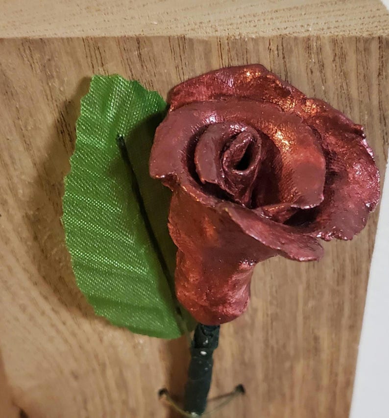 Mother's Day or any day Gift for her clay Rose on Wooden background. Bronze