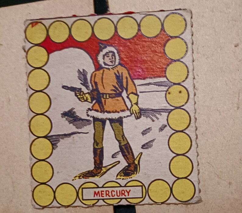 May include: A vintage game card featuring a cartoon illustration of a person wearing a fur-trimmed parka and snowshoes, holding a gun. The card has a yellow border with a circle pattern and the word "MERCURY" printed at the bottom.