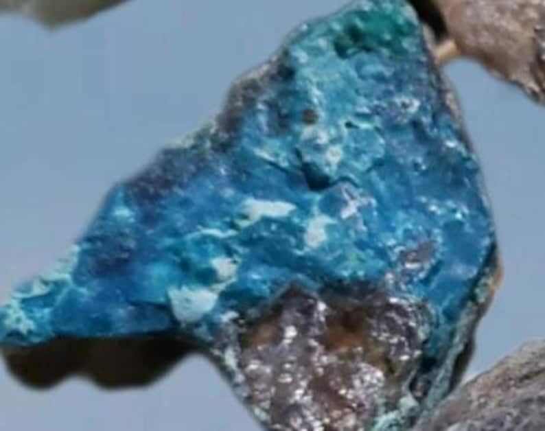 May include: A close-up of a blue and white mineral specimen. The mineral has a rough, textured surface and a variety of shades of blue.
