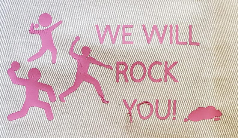 May include: Off-white fabric with pink text and graphics. The text reads "WE WILL ROCK YOU!" with three stylized figures throwing objects. A pink cloud-like shape is also present.