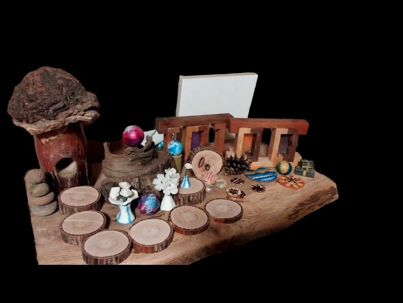 May include: A collection of miniature wooden and ceramic decorative items, including a mushroom house, Stonehenge replica, and small tree slices. The arrangement features various colors and textures, set on a wooden base.