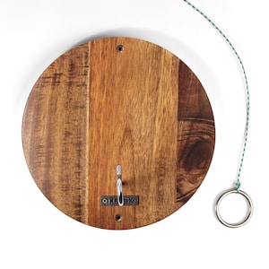 May include: A wooden ring toss game with a circular wooden base and a metal hook. A metal ring is attached to a rope.