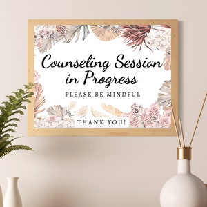 May include: A sign with a floral and botanical design that reads "Counseling Session in Progress. Please be mindful. Thank you!"