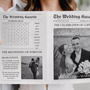 Peut inclure: Un journal de mariage en noir et blanc intitulé "The Wedding Gazette" tenu par une personne. Le journal présente une recherche de mots, des photos du couple et le texte "ARE GETTING MARRIED!"