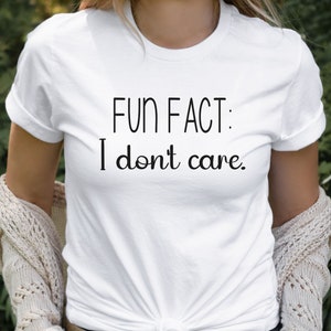 May include: White t-shirt with black text that reads "FUN FACT: I don't care."