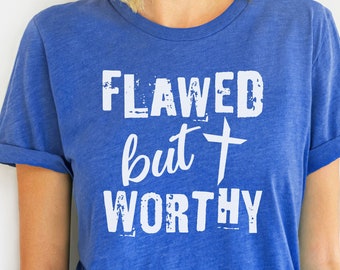 May include: A royal blue t-shirt with a white distressed graphic that reads "Flawed but + Worthy".