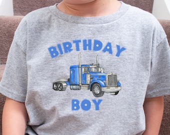 Może przedstawiać: Szara koszulka z nadrukiem niebieskiego ciągnika siodłowego i napisem "Birthday Boy" w kolorze niebieskim.