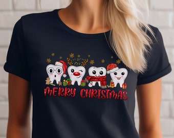 Op de afbeelding: Een donkerblauw t-shirt met een kerstthema met vijf cartoon-tanden die kerstmanmutsen en rendiergewei dragen. De tekst "Merry Christmas" is onder de tanden gedrukt.