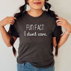May include: A dark gray t-shirt with the text "FUN FACT: I don't care." printed in white.