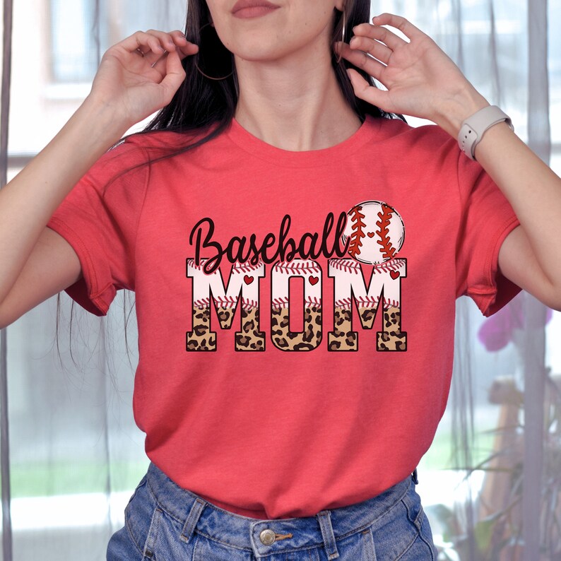 May include: Red t-shirt with a baseball graphic and the text "Baseball Mom" in white letters with a leopard print design.