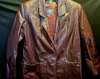 May include: A brown leather blazer with a single button closure and two pockets. The blazer has a label that reads "Giorgio Sant'Angelo Made in Italy".