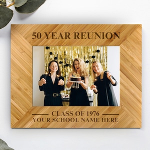 May include: A rectangular bamboo photo frame featuring a light wood grain finish. The top border is engraved with 50 YEAR REUNION, and the bottom border displays CLASS OF 1976 and YOUR SCHOOL NAME HERE. The frame holds a photo of three people.