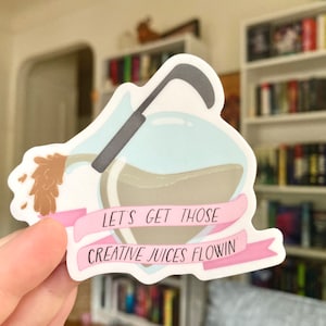 Puede incluir: Una pegatina con una ilustración de dibujos animados de una botella de poción con una pancarta rosa que dice "Let's get those creative juices flowin'"