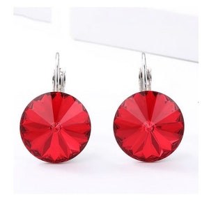 May include: A pair of red crystal earrings with silver hooks. The crystals are round and have a faceted design.