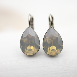 Puede incluir: Un par de pendientes de plata en forma de lágrima con cristales transparentes y facetados.