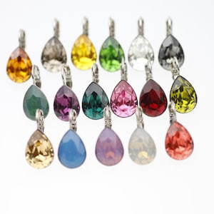Puede incluir: Surtido de pendientes de cristal en forma de lágrima en varios colores, incluyendo rojo, verde, azul, morado, rosa, amarillo, naranja y transparente.