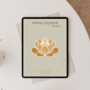 May include: A digital tablet displays a beige graphic with a lotus flower illustration in shades of orange and white. The text "SPRING EQUINOX Emergence" is at the top, and "SOUTH2NORTH CREATIONS" is at the bottom. The tablet is on a white surface.