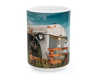 Puede incluir: Taza de cerámica blanca con un diseño de tractor Ford vintage. El tractor está desgastado con óxido y sobre un fondo de cielo azul y hierba alta. La taza tiene un acabado brillante.