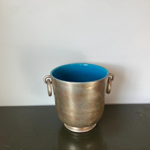 Puede incluir: Cubo de hielo de plata con interior de esmalte azul y dos asas.