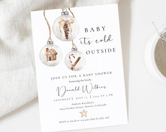 May include: A baby shower invitation with the text "BABY its cold OUTSIDE". The invitation features watercolour illustrations of Christmas baubles with a gingerbread house, cinnamon stick, and dried flowers inside. The invitation is on a white background.