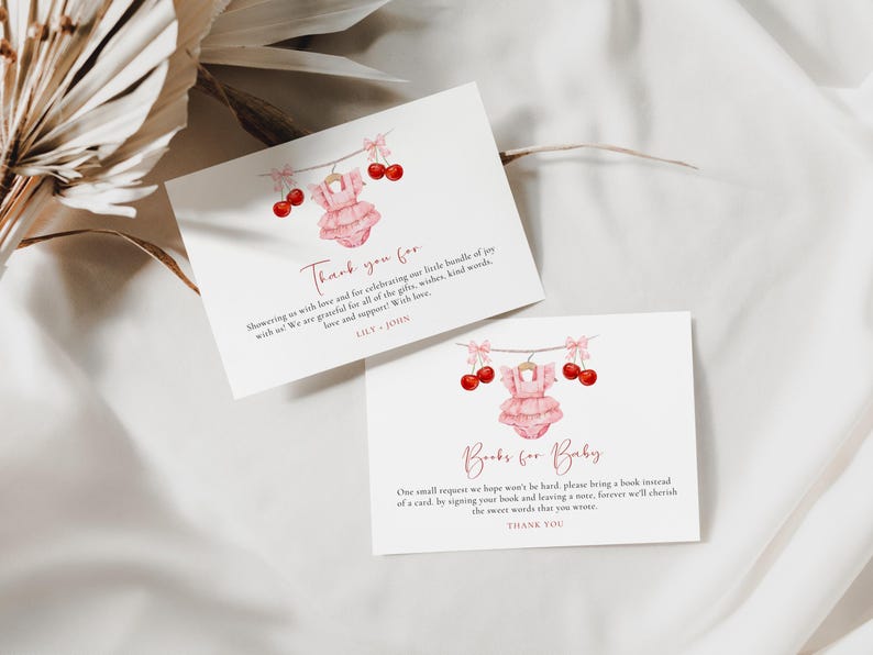 Puede incluir: Dos tarjetas rosas y blancas con una ilustraci&oacute;n de acuarela de un atuendo de beb&eacute; y cerezas. El texto en las tarjetas dice "Gracias por darnos tanto amor y por celebrar nuestro peque&ntilde;o paquete de alegr&iacute;a con nosotros. Estamos agradecidos por todos los regalos, deseos, palabras amables, amor y apoyo. Con amor, Lily & John" y "Libros para beb&eacute;. Una peque&ntilde;a petici&oacute;n que esperamos no sea dif&iacute;cil, por favor traiga un libro en lugar de una tarjeta, firmando su libro y dejando una nota, siempre apreciaremos las dulces palabras que escribi&oacute;. Gracias."