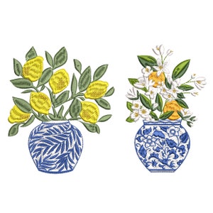 May include: Two blue and white porcelain vases with floral arrangements. One vase holds yellow lemons and green leaves, the other holds white flowers and orange citrus fruit.