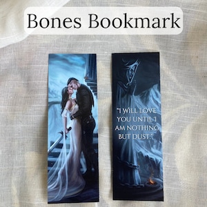 Pu&ograve; includere: Due segnalibri a tema fantasy. Uno raffigura una coppia che si abbraccia, l'altro presenta una figura incappucciata con la citazione "I WILL LOVE YOU UNTIL I AM NOTHING BUT DUST." Il titolo "Bones Bookmark" &egrave; in alto.