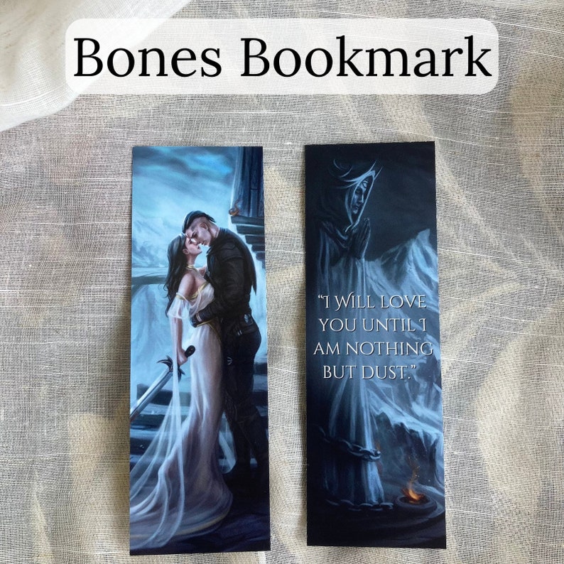 Pu&ograve; includere: Due segnalibri a tema fantasy. Uno raffigura una coppia che si abbraccia, l'altro presenta una figura incappucciata con la citazione "I WILL LOVE YOU UNTIL I AM NOTHING BUT DUST." Il titolo "Bones Bookmark" &egrave; in alto.