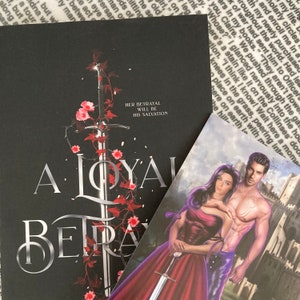 May include: A black book cover with a silver sword and red flowers. The title of the book is "A Loyal Betrayal" and the subtitle is "Her Betrayal Will Be His Salvation".