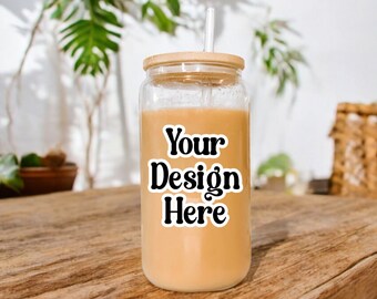 May include: A clear glass jar with a bamboo lid and a straw, filled with a light brown liquid. The jar has a white sticker with the text "Your Design Here" in black.
