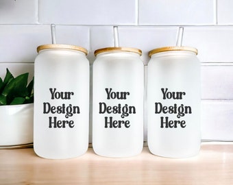May include: Three frosted glass tumblers with bamboo lids and clear drinking straws. Each tumbler has the text "Your Design Here" printed on the front.