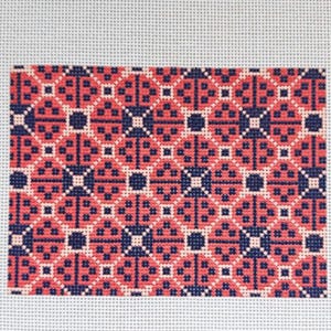May include: A needlepoint canvas featuring a repeating geometric pattern in navy blue, coral, and cream. The design consists of interconnected diamond shapes with small cross-stitch details. A color key with three small squares is visible in the top right.