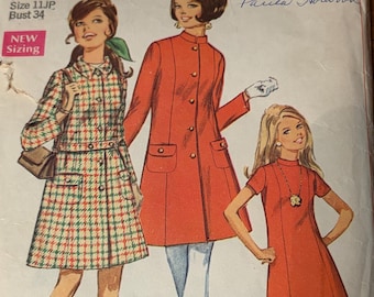 May include: Vintage Simplicity sewing pattern envelope featuring three illustrated women's fashion designs. The envelope is labeled "7874" and includes text indicating "Junior Petite" sizing. The designs include a coat and two dresses.