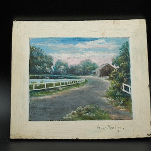 May include: A framed painting of a rural landscape with a white picket fence, a road, and a small building in the distance. The painting is signed "H.C. Mac Millan".