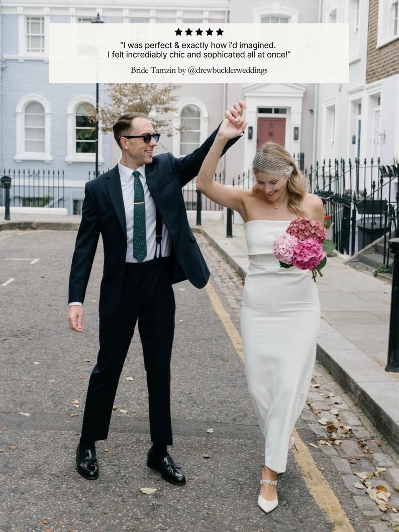 May include: A couple celebrates on a cobblestone street. The person on the left wears a dark suit, sunglasses, and a green tie. The person on the right wears a white strapless dress and carries a bouquet of pink flowers. Text reads: "I was perfect & exactly how I'd imagined."