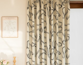 May include: A pair of cream-colored curtains with a black abstract pattern of lines and curves. The curtains are hung on a gold rod.