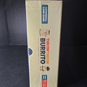 May include: A yellow box with a cartoon burrito on the front. The box says "Throw Throw Burrito" and "A Dodgeball Card Game". The box is shrink-wrapped.